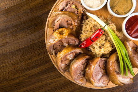 Roasted Pork Roulade with boiled cabbage and sauces on wooden tray. Up viewの写真素材