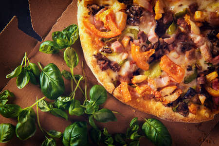 Slices of pizza on cardboard with basil. Top view. Close-upの写真素材