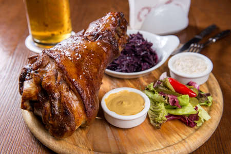 Roasted knuckle of pork with boiled cabbage, horseradish and mustard, served  a mug  cold beerの写真素材