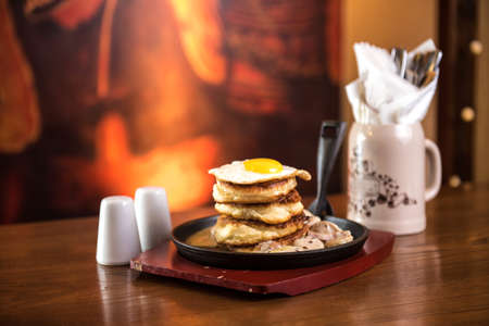 Pancakes with sausage and scrambled eggs in a frying pan.の写真素材