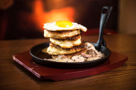 Pancakes with sausage and scrambled eggs in a frying panの写真素材