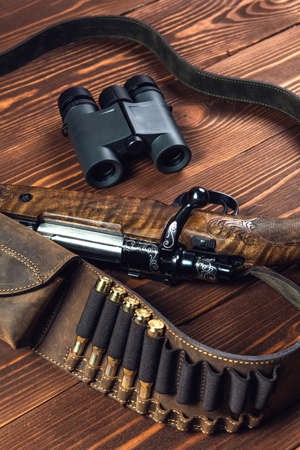 Hunting equipment on old wooden background and bullets.の写真素材