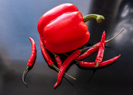 Red hot chili peppers and chilli on a black wooden background.の写真素材