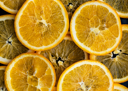 Slices of fresh orange on a dark background. top view.の写真素材
