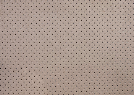 Closeup of textured surface of beige fabric with small holesの写真素材