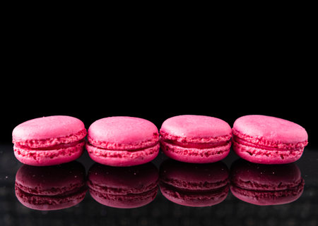 Pink macaroons on a black background. Place for text.の写真素材