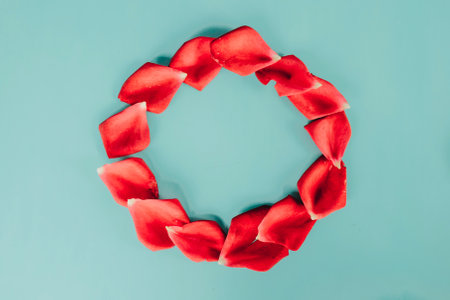 Red rose petals on blue background. Flat lay, top viewの写真素材