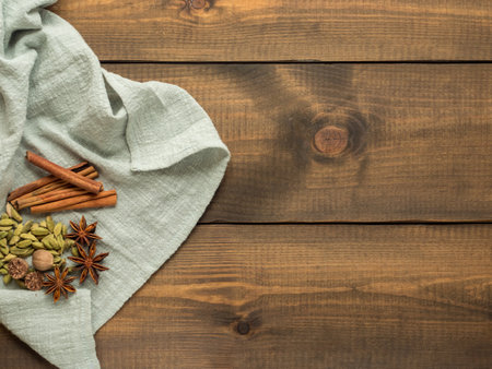 Two mugs with masala tea stand on a wooden table with spices. Top view. Copy space.の写真素材