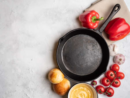 Empty pan on a concrete surface, top view. Around are various vegetables.の写真素材