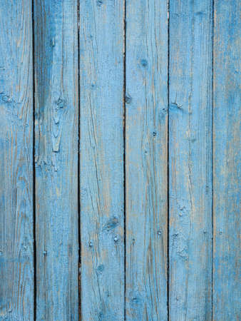 Old wooden planks covered with peeling blue paint.の写真素材