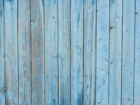Old wooden planks covered with peeling blue paint.の写真素材