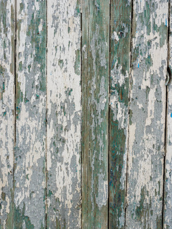 Old wooden planks covered with peeling white and green paint.の写真素材