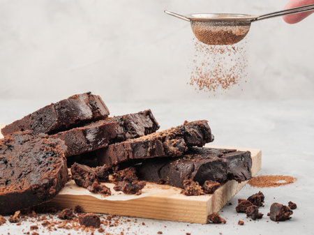 A chopped pound chocolate cake sprinkle of cocoa powder. White background, horizontal photo.の写真素材