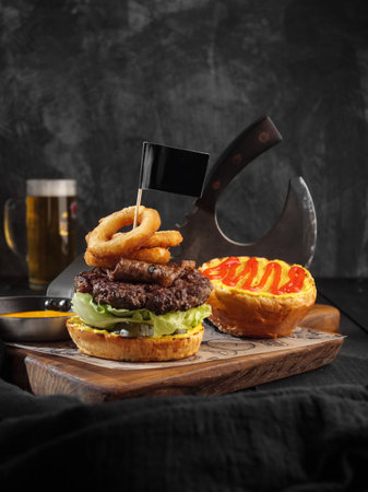 Burger with onion rings and a flag on a dark background. Mug of beer. Copy space.の写真素材