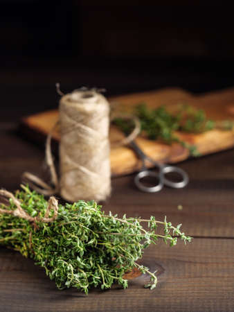 A bunch of thyme on a wooden table with a jute rope.の写真素材