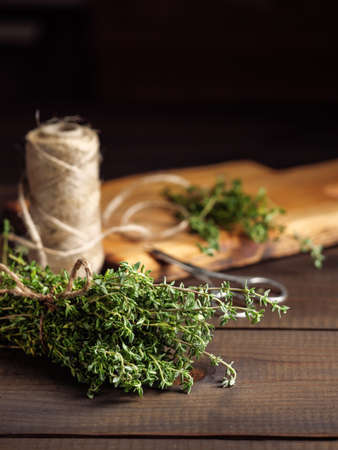 A bunch of thyme on a wooden table with a jute rope.の写真素材