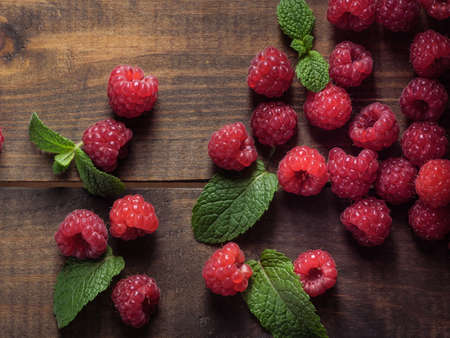 Raspberry and peppermint berries on a wooden table, top view.の写真素材