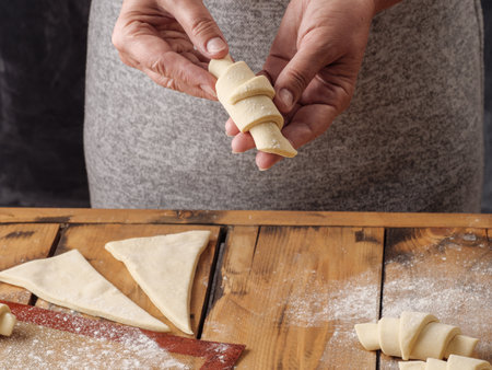 A woman holds an unbaked croissant in her hand. Copy space.の写真素材