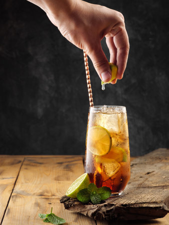 Classic cocktail Cuba Libre on a wooden table, copy space.の写真素材