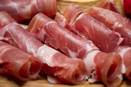 Prosciutto, sliced meat on a wooden tray