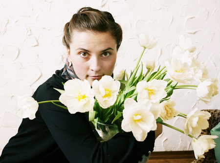 Beautiful young girl with flowers on a white.の写真素材