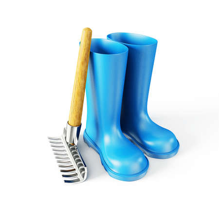 blue wellingtons and rake isolated on a whiteの写真素材