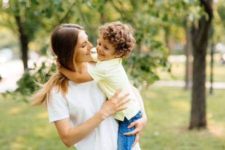 Portrait of happy loving mother and her baby outdoors.の写真素材