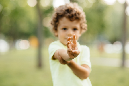 Young boy looks with fingers read years hasの写真素材