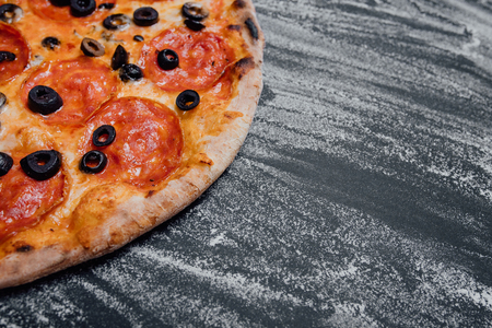 Tasty pepperoni pizza and cooking ingredients tomatoes, black background with flour, Top view. Banner, close-up, copy space for textの写真素材