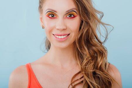close up, beautiful young girl smiles, looking into the camera, positive facial emotions, isolated on blue backgroundの写真素材