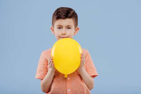 little boy with yellow balloon. looks at the camera,の写真素材