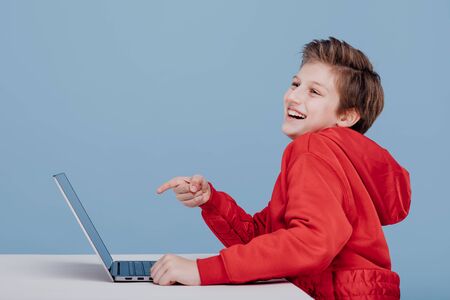 happy excited child pointing finger at laptopの写真素材
