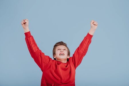 Happy schoolboy celebrating victory in studioの写真素材
