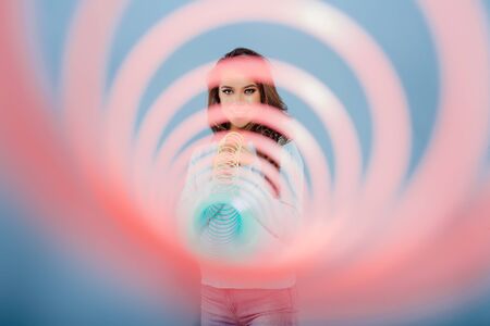 Happy teennager smiling for camera and playing with spring toyの写真素材