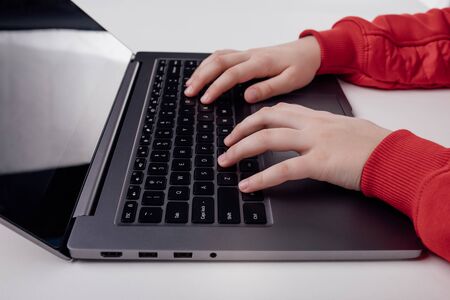 Cropped view of Childs hand typing on laptopの写真素材