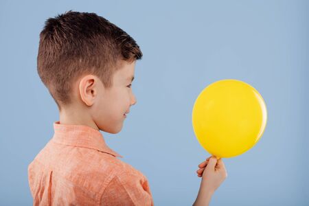 child. little boy holds a yellow balloon.の写真素材