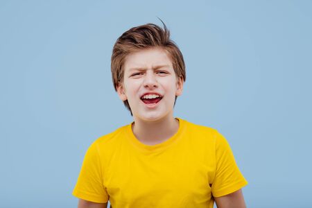 screaming boy looks at camera in yellow t-shirtの写真素材