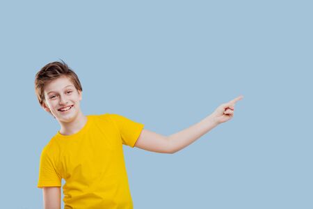 smiling boy pointing his finger to the left sideの写真素材