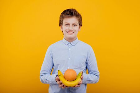 nice preteen child boy with fruit look at the cameraの写真素材