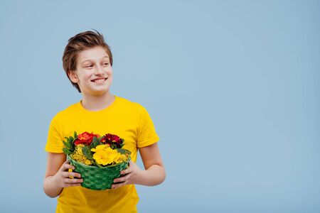 happy preteen boy with basket of flowers in his hand,の写真素材