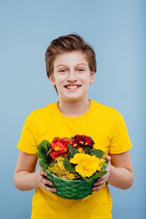 happy boy with basket of flowers in his handの写真素材