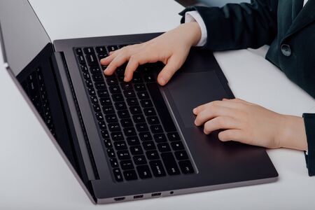 close up view of Child's hand typing on laptop computer at table, top viewの写真素材