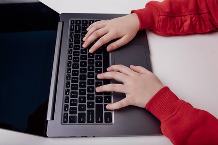 Child's hand on a laptop keyboard. isolated on white background, close upの写真素材