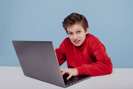 child boy near the table with laptopの写真素材
