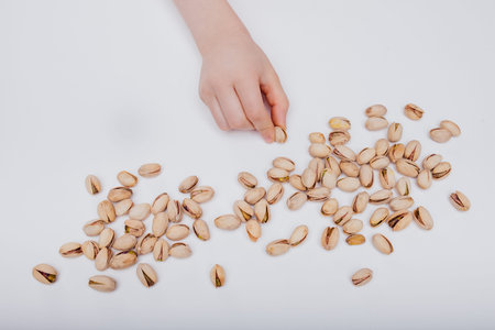 close up, Detail of childs hands, holding of organic pistachio. isolated on white backgroundの写真素材