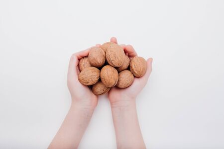 close up, walnuts in the hands of a child isolated on white backgroundの写真素材