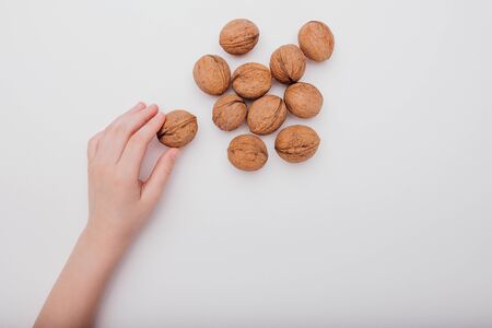 close up, child hand with many walnuts isolated on white background, top viewの写真素材