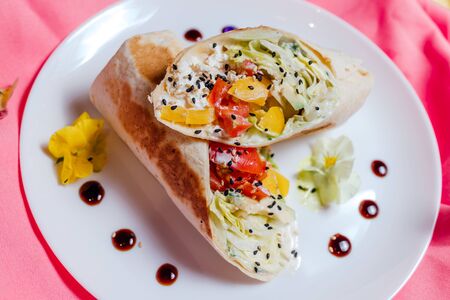 vegan Wrap iceberg, pickled cucumbers, celery, tomatoes, carrot, tofu, on plate on pink background, close up, top viewの写真素材