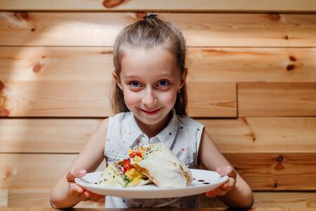 picnic. little girl with vegetarian Wrap iceberg pickled cucumbers, celery carrot tofu.の写真素材
