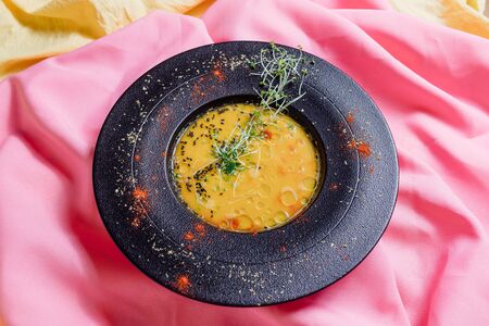 pumpkin soup on a yellow background, top view, vegetarian foodの写真素材